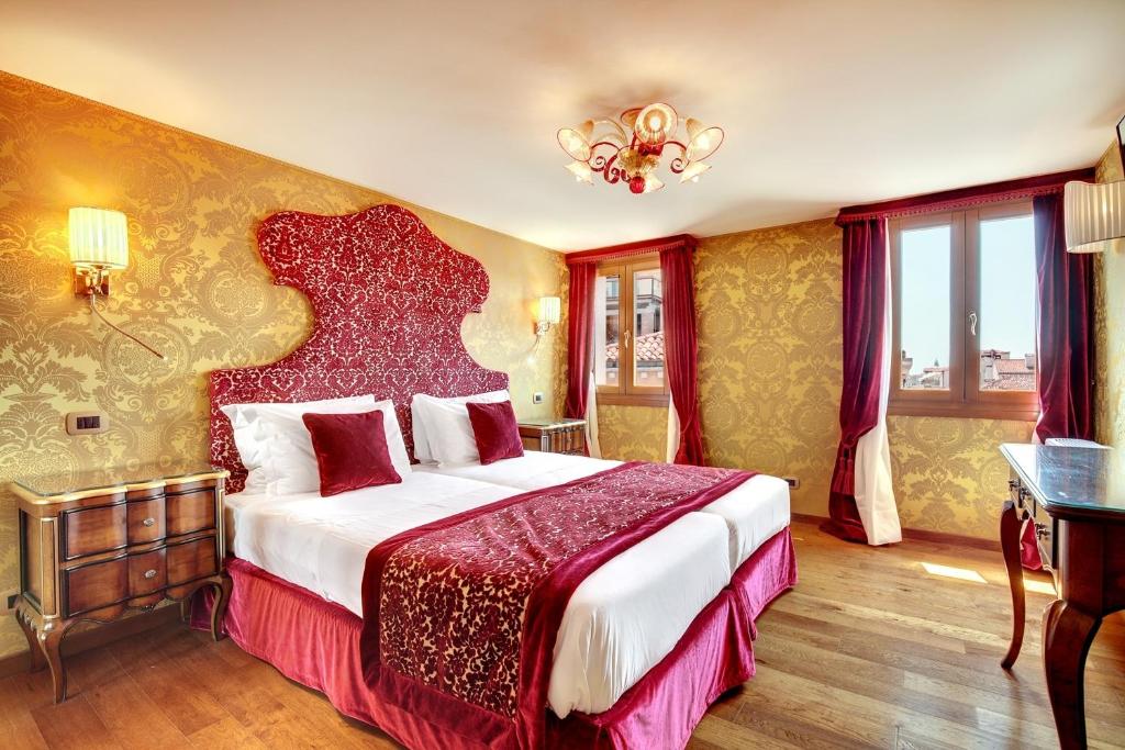 a bedroom with a large bed and a large window at Hotel Casanova in Venice