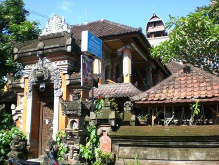 a large house with a building with a roof at Nuriani Guest House in Ubud