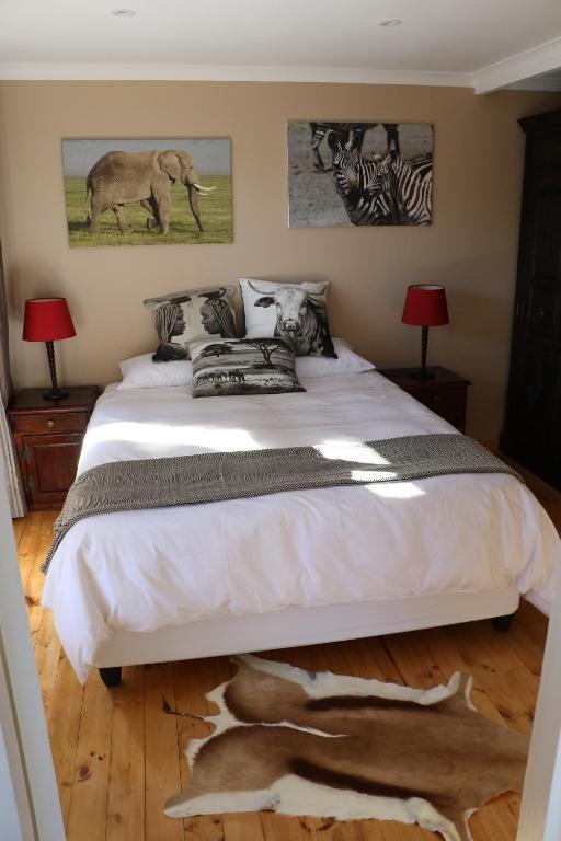 a bedroom with a large bed with a animal on the floor at Allan Grove 2 in Knysna