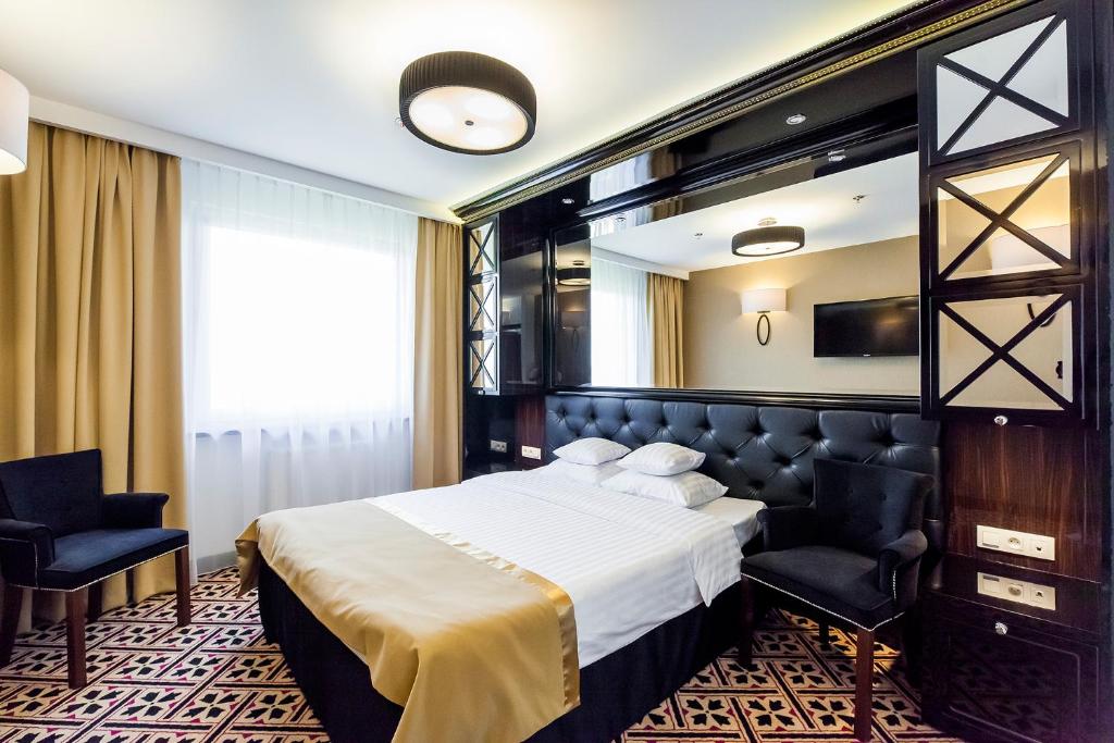 um quarto de hotel com uma cama e um espelho em Hotel 500 em Zegrze