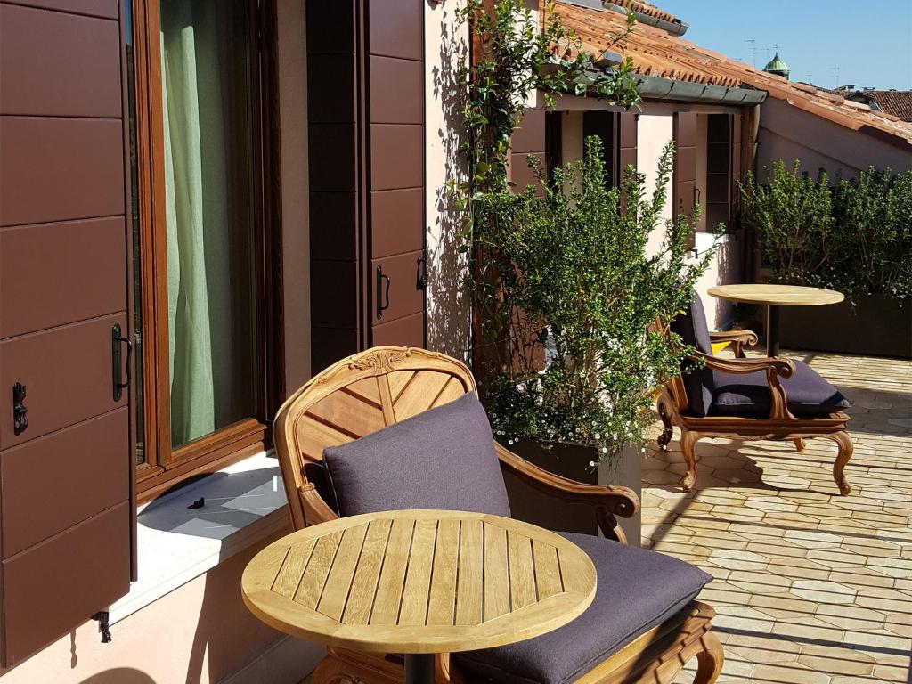a chair and a table on a balcony at Palazzo Venart Luxury Hotel in Venice
