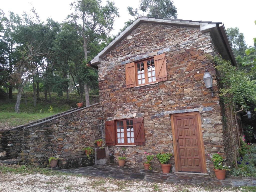 Casa de piedra antigua con puertas y ventanas de madera en Casa da Lomba, en Arganil
