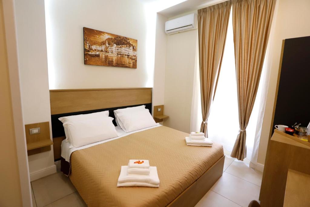 una camera d'albergo con un letto e due asciugamani di VICTORIA HOTEL B&B a Napoli