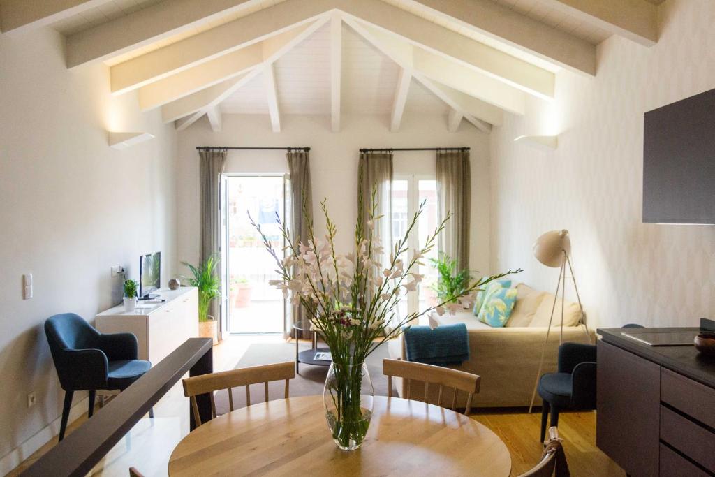 een woonkamer met een vaas met bloemen op een tafel bij Apartamentos Santa Maria by Heart of Funchal in Funchal