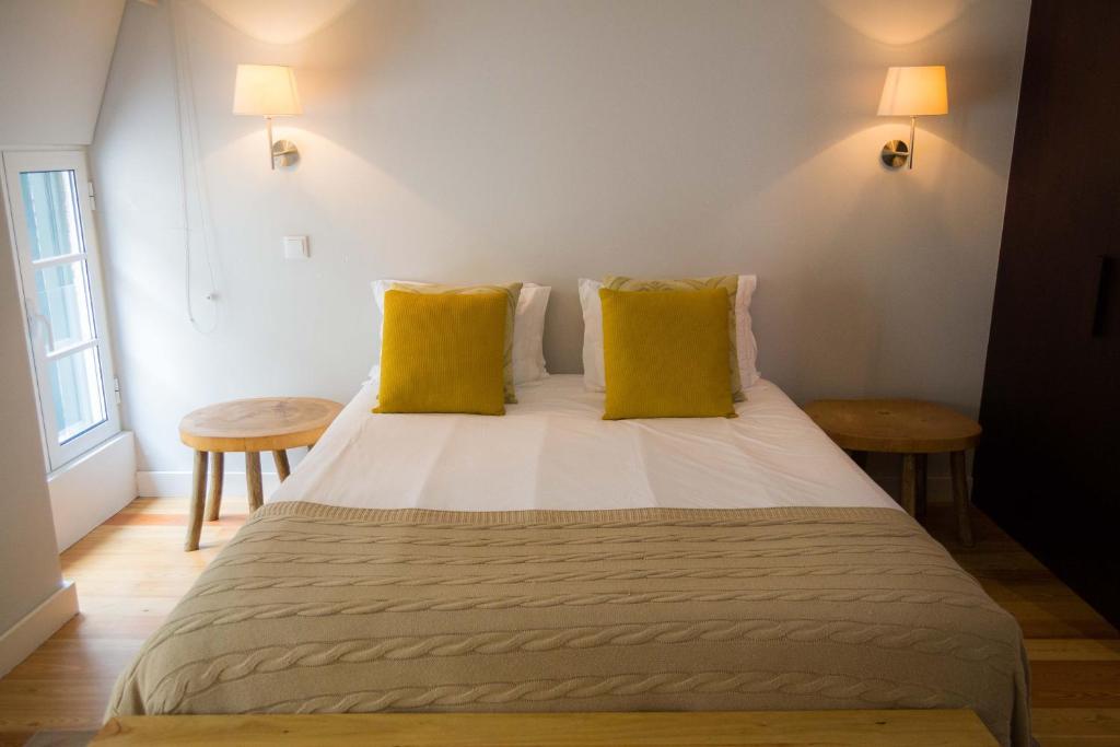 een slaapkamer met een groot bed met gele kussens bij Apartamentos Santa Maria by Heart of Funchal in Funchal