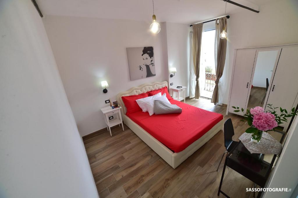 una camera con letto rosso e specchio di Suite Varigotti a Varigotti