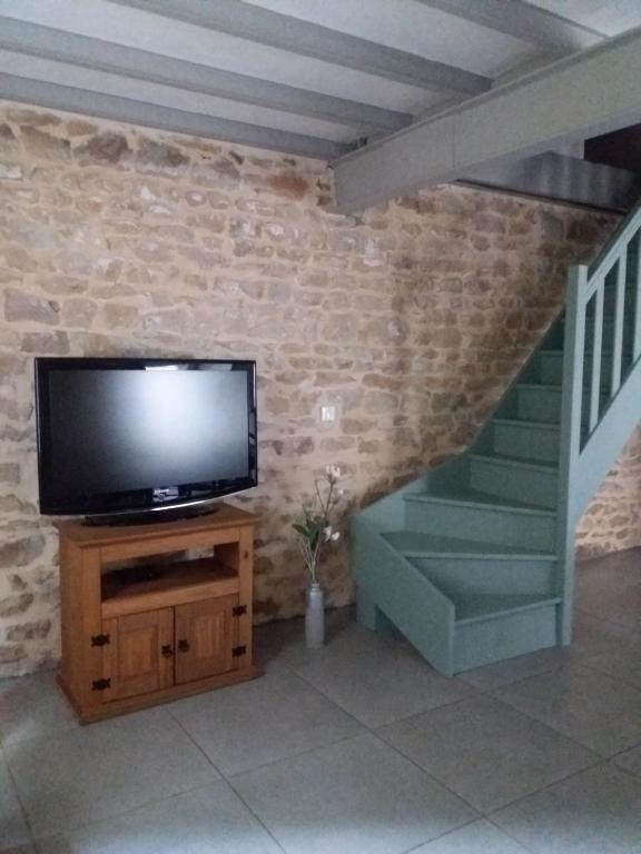 a television sitting on a stand next to a staircase at Meublé de tourisme &quot;Les brosses tillots&quot; in Mary