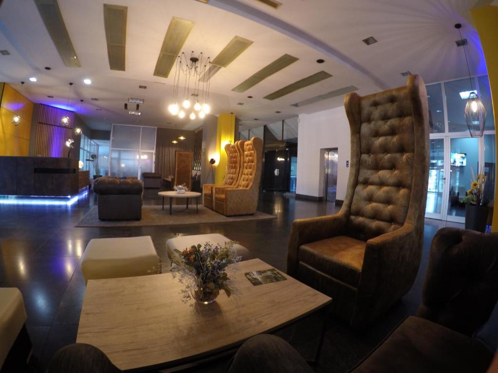 a lobby with chairs and a table in a room at Business Hotel Prijedor in Prijedor