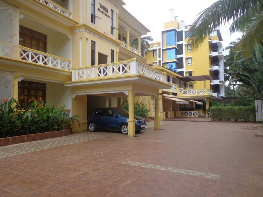 a car parked in a parking lot in front of a building at The Tubki Resort in Palolem