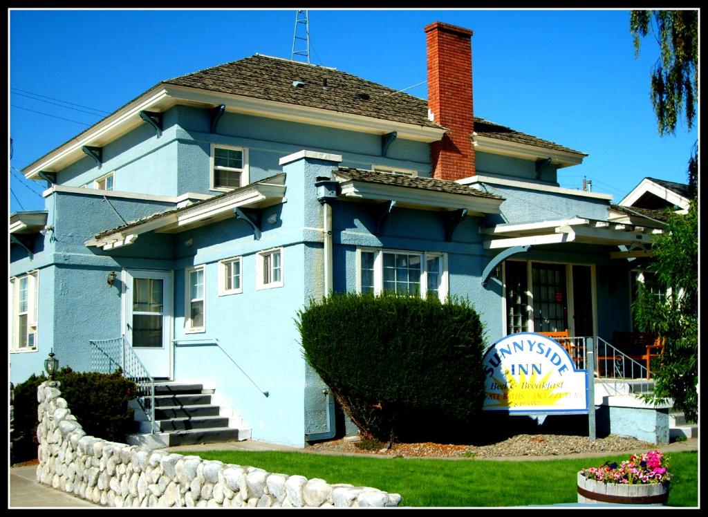 una casa azul con un cartel delante en Sunnyside Inn Bed &Breakfast, en Sunnyside