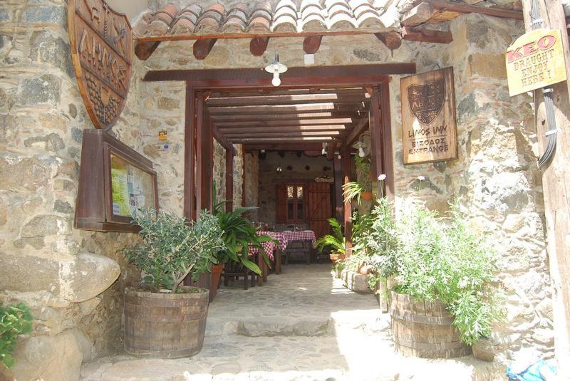une entrée à un bâtiment en pierre avec des plantes en pot dans l'établissement Linos Inn, à Kakopetriá