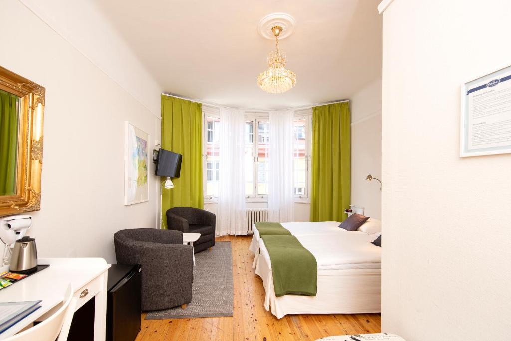 una camera d'albergo con letto e soggiorno di Hotel Emma a Östersund