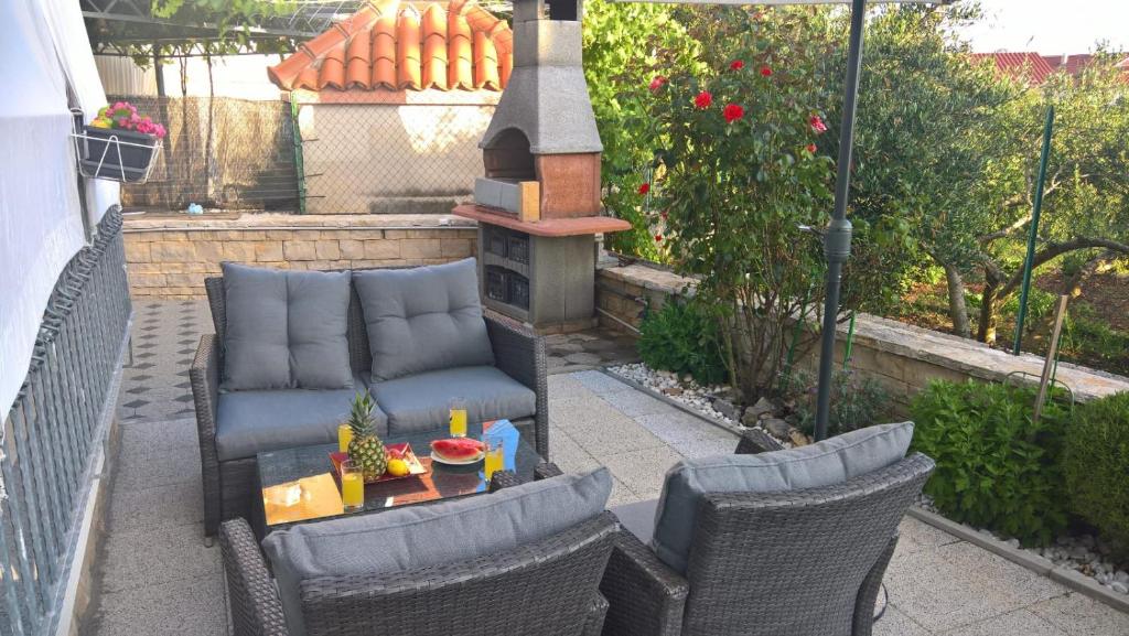 a patio with a couch and chairs and a grill at Apartment Diva Exclusive in Zaboric