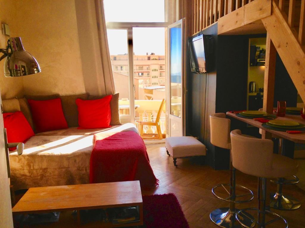 ボーソレイユにあるappartement Monaco Beausoleilのベッドルーム1室(赤い枕のベッド1台、窓付)