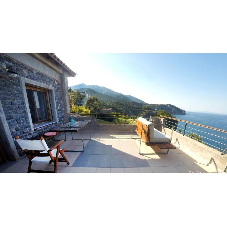 a house with a balcony with a view of the ocean at Frictories station of residency in Limniónas