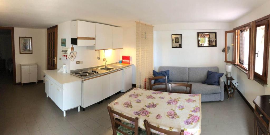 a kitchen and a living room with a table at casa elba relax in Rio nellʼElba