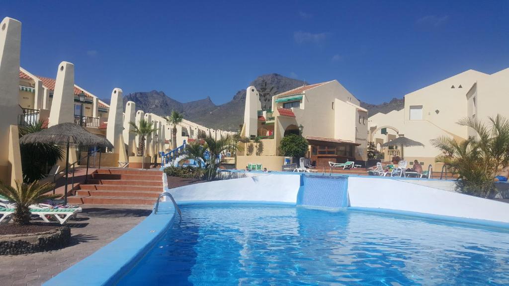 ein Pool in einem Resort mit Bergen im Hintergrund in der Unterkunft Apartamento Mare Verde in Adeje