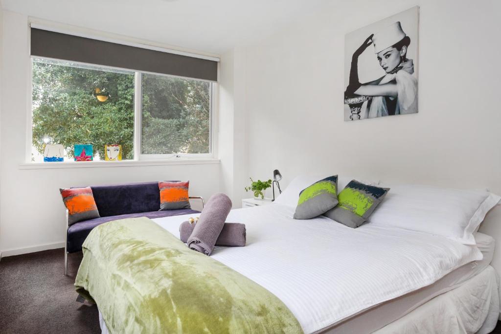 a large white bed in a room with a window at Melbourne Villa in Melbourne