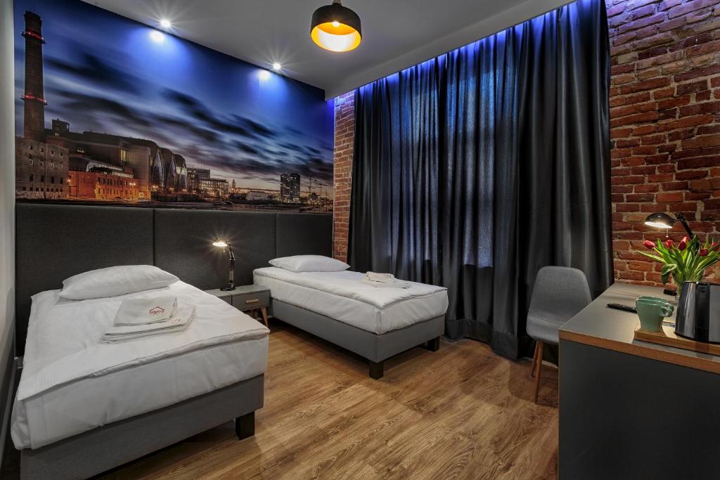 sypialnia z 2 łóżkami i ceglaną ścianą w obiekcie ADLER Bed&Breakfast w Łodzi