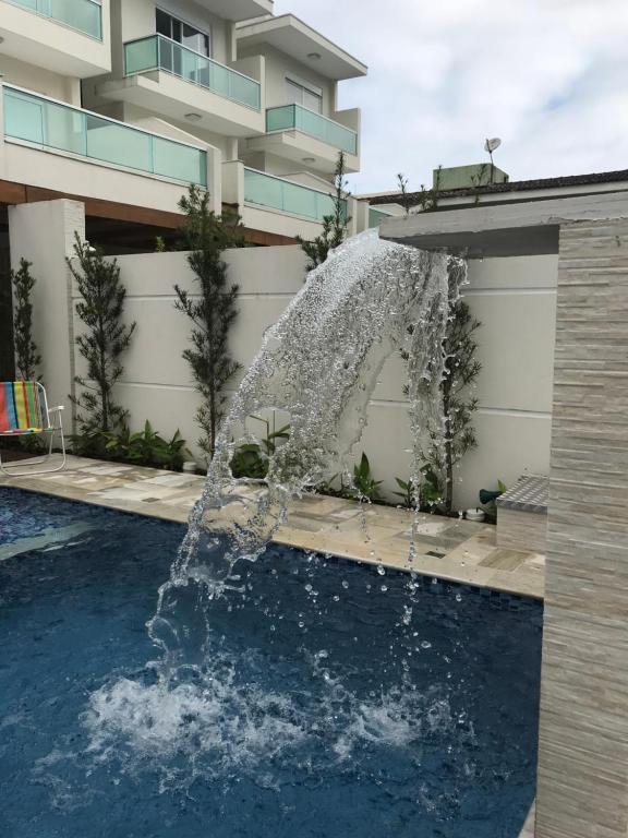 einen Brunnen in einem Pool vor einem Gebäude in der Unterkunft Villaggio Juquehy in Juquei