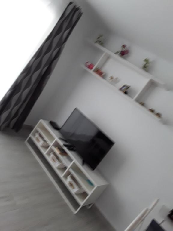 salon z telewizorem i białą półką w obiekcie Le parisien w Costa Teguise