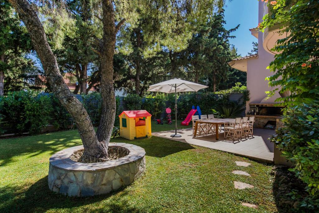 アテネにあるNorthside Privé Garden Athens Luxurious Villa & Poolの木とテーブルと遊び場のある裏庭