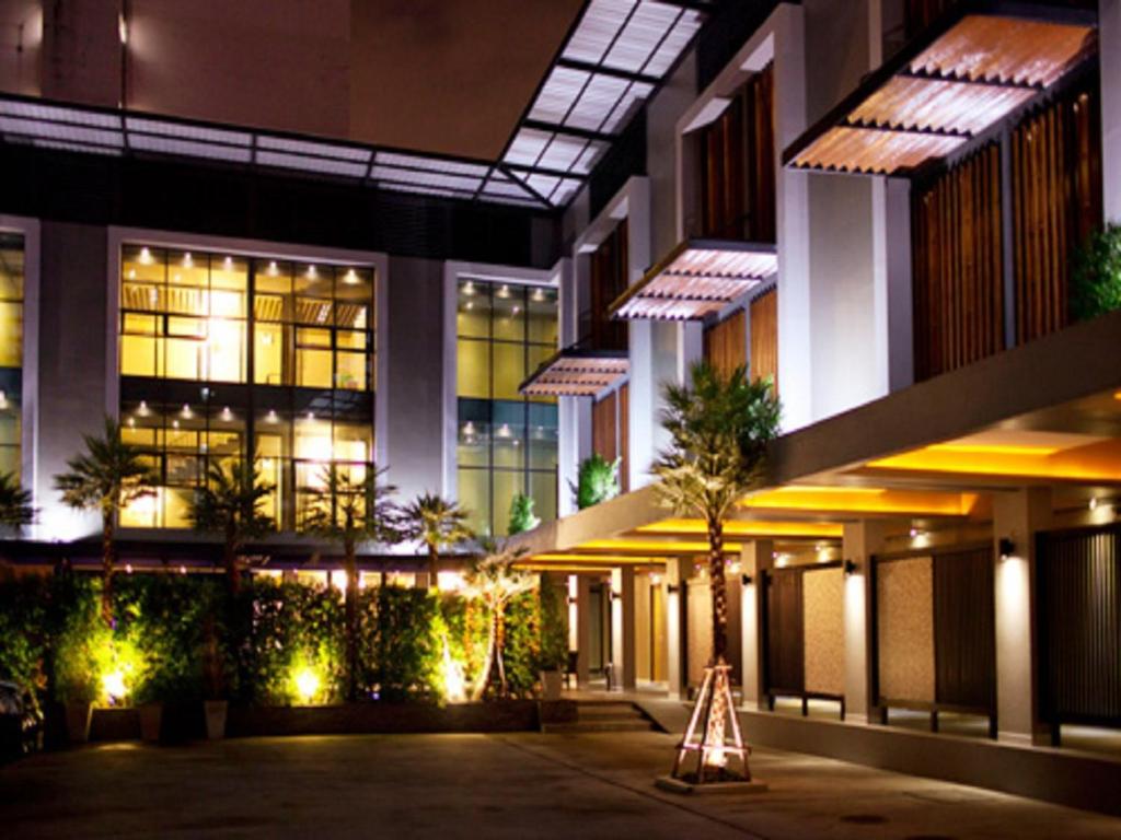 曼谷的住宿－暹羅思瓦納酒店，一座建筑在晚上,前面有标志