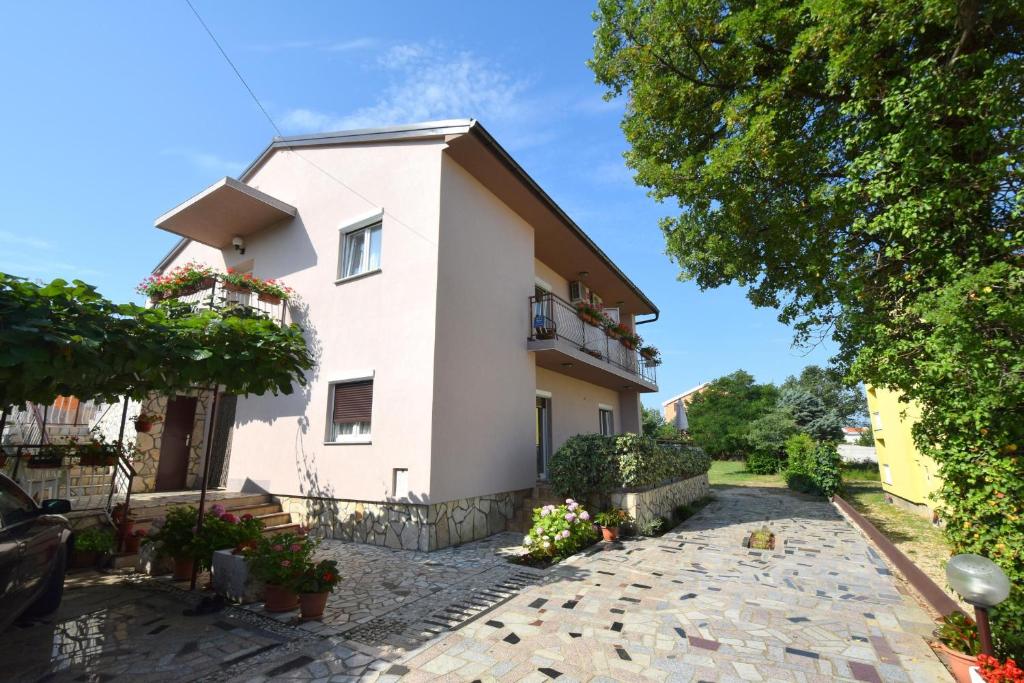 Casa blanca con balcón y entrada en Apartments Josipa, en Malinska