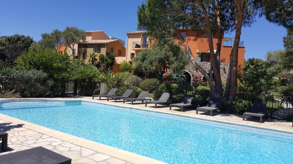 a swimming pool with lounge chairs next to a house at Résidence A Merula in Calvi