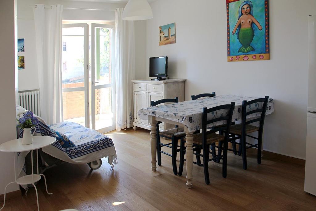 jadalnia ze stołem, krzesłami i telewizorem w obiekcie Appartamento mare Sirolo con garage privato w mieście Sirolo