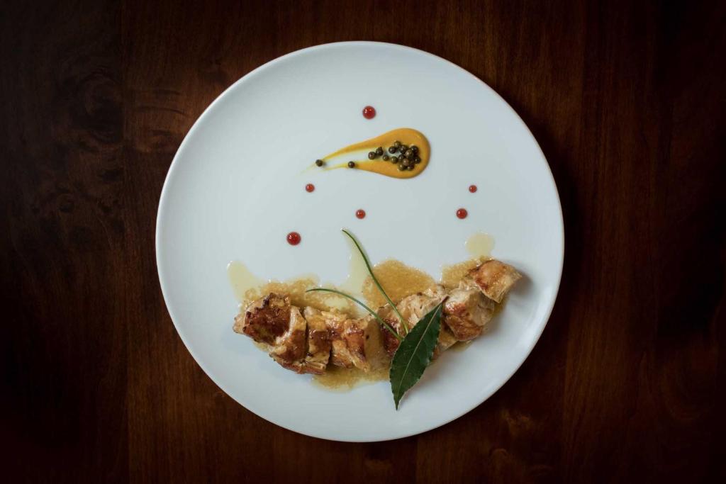 a white plate with food on a wooden table at Il Feudo in Vo Euganeo