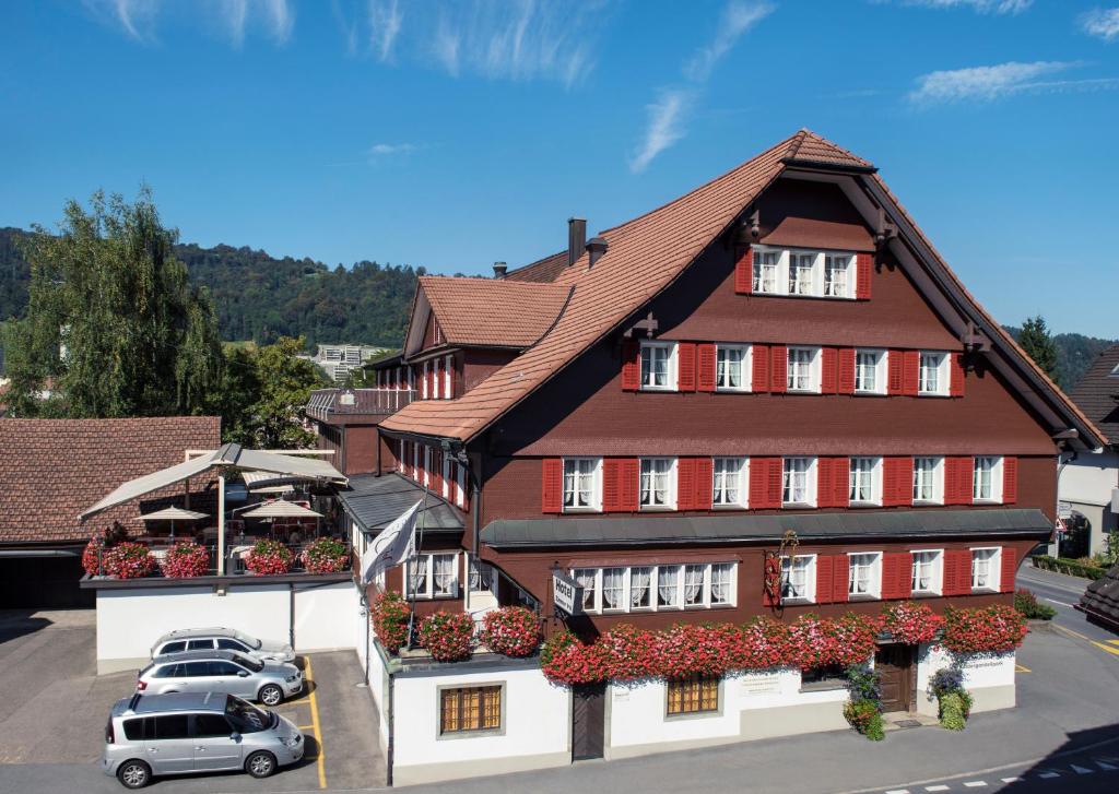 un edificio con coches estacionados frente a él en Hotel Kreuz, en Malters