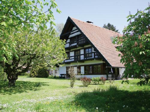 une grande maison noire et blanche avec des arbres et de l'herbe dans l'établissement Gästehaus Obsthof Gottenheim, à Gottenheim