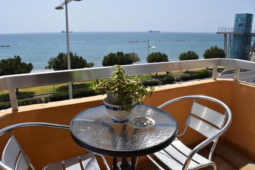 un tavolo in vetro su un balcone con una pianta di Mediterranean Breeze a Limassol