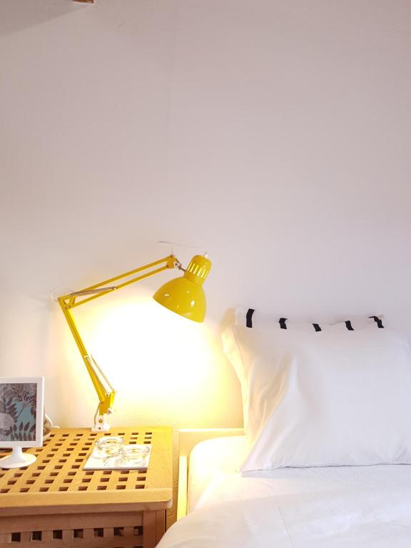 a bed with a lamp on a table next to a bed at Casa de Sistelo - Turismo Rural Gerês in Sistelo