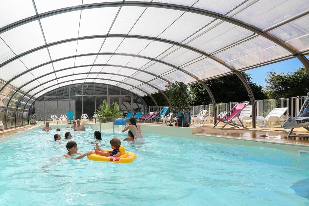 - un groupe d'enfants jouant dans une piscine avec une arcade dans l'établissement Le Vallon aux merlettes, à Matignon