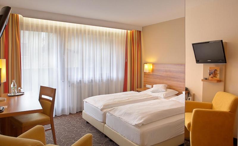 Postel nebo postele na pokoji v ubytování Flair Hotel Weinstube Lochner