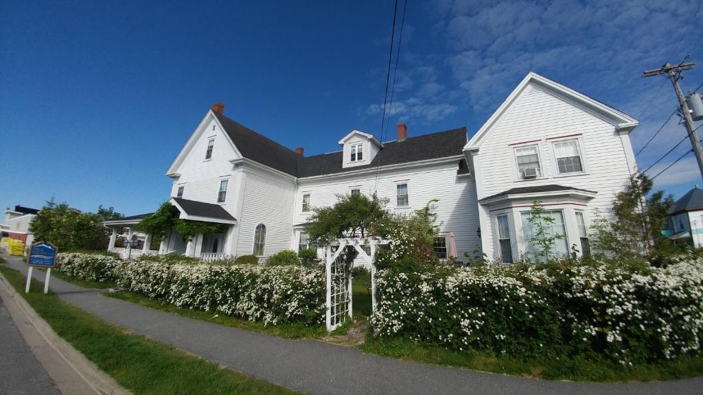 uma casa branca com um arco em frente em Inn on Frederick em Saint Andrews