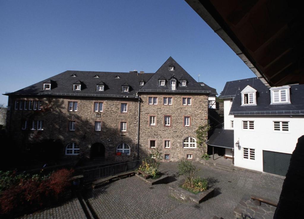 モンシャウにあるFerienwohnungen Burg Monschauの黒屋根の大きなレンガ造り