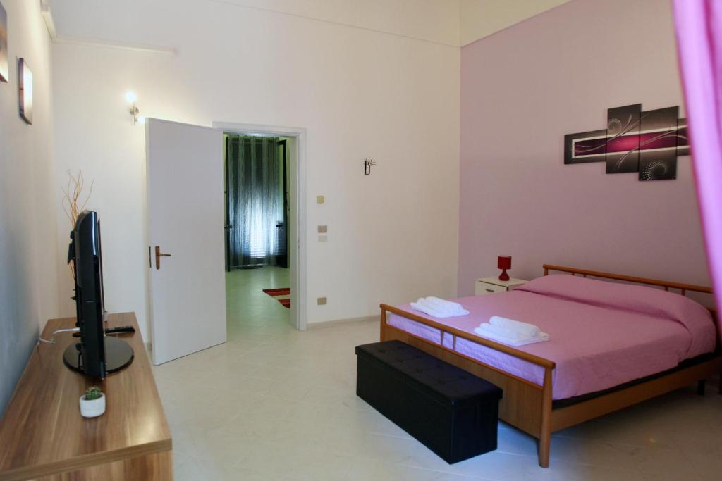 ein Schlafzimmer mit einem Bett und einem TV. in der Unterkunft Casa Amalia in Lecce