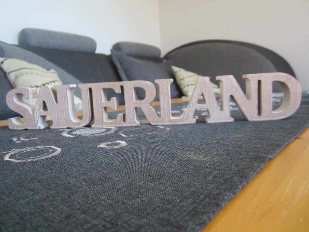 a blanket with the word scarard on a bed at Ferienwohnung Mause in Medebach