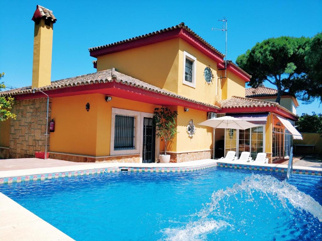 a house with a swimming pool in front of a house at Villa La Jara in El Puerto de Santa María