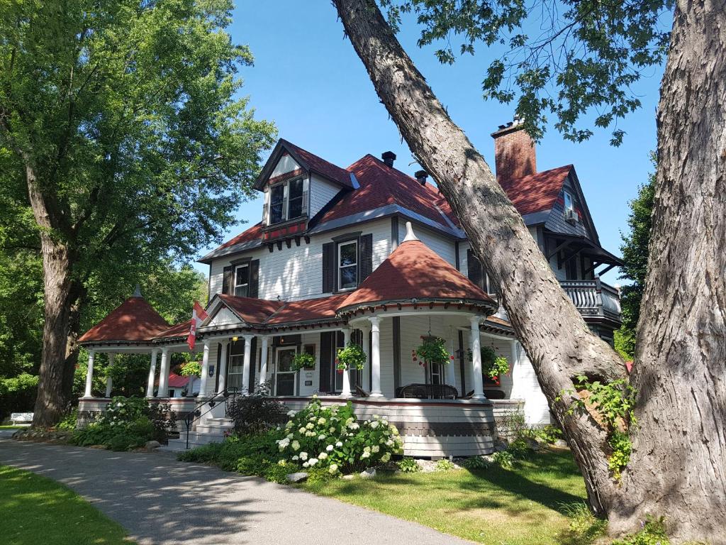 a black and white house with a red roof at Les Trois Erables Boutique Inn in Wakefield