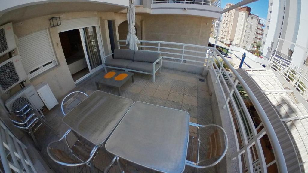 a balcony with a table and chairs on a ship at Mejores Apartamentos-dulpex Hukako en Playa de Gandia in Gandía