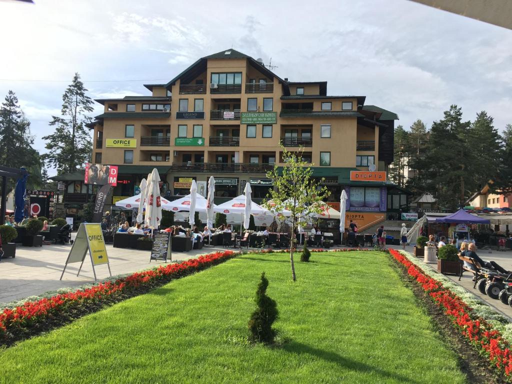 a large building with a lawn in front of it at Apartment Vila Jezero in Zlatibor