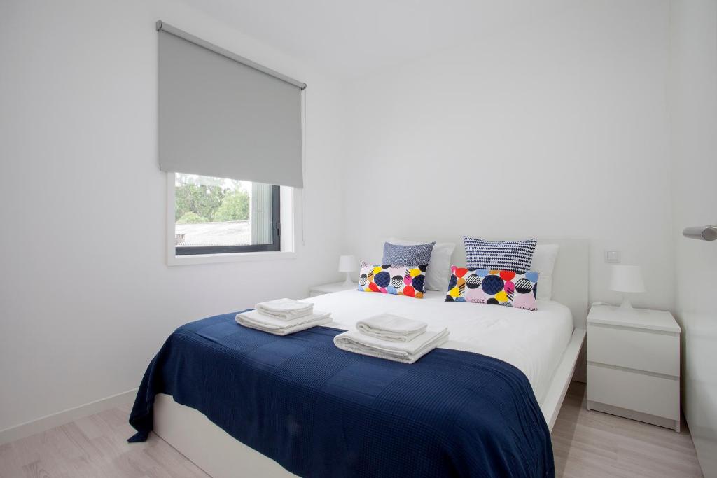 ポルトにあるLiiiving in Porto | Santa Catarina Cosy Apartmentの白いベッドルーム(青い毛布付きのベッド付)