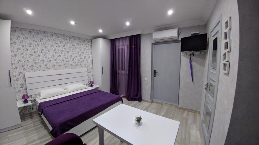1 dormitorio con cama, mesa y TV en L&S Apartment at old Tbilisi, en Tiflis