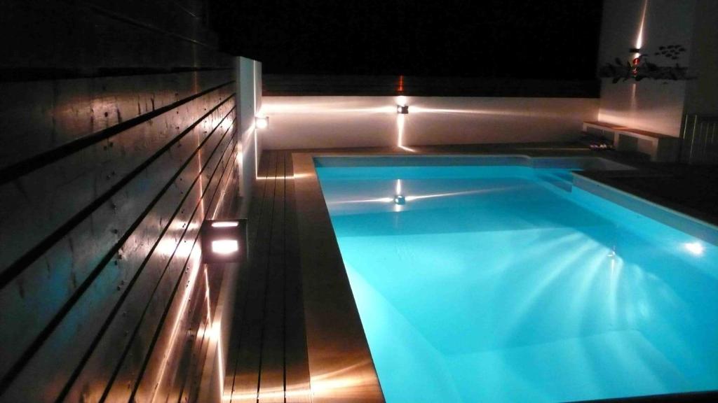een zwembad in een huis met verlichting bij Casa Coloridos in Óbidos