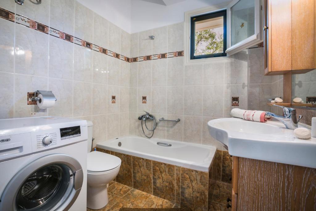 a bathroom with a washing machine and a sink at Apartment Voula Myrtos in Anomeriá