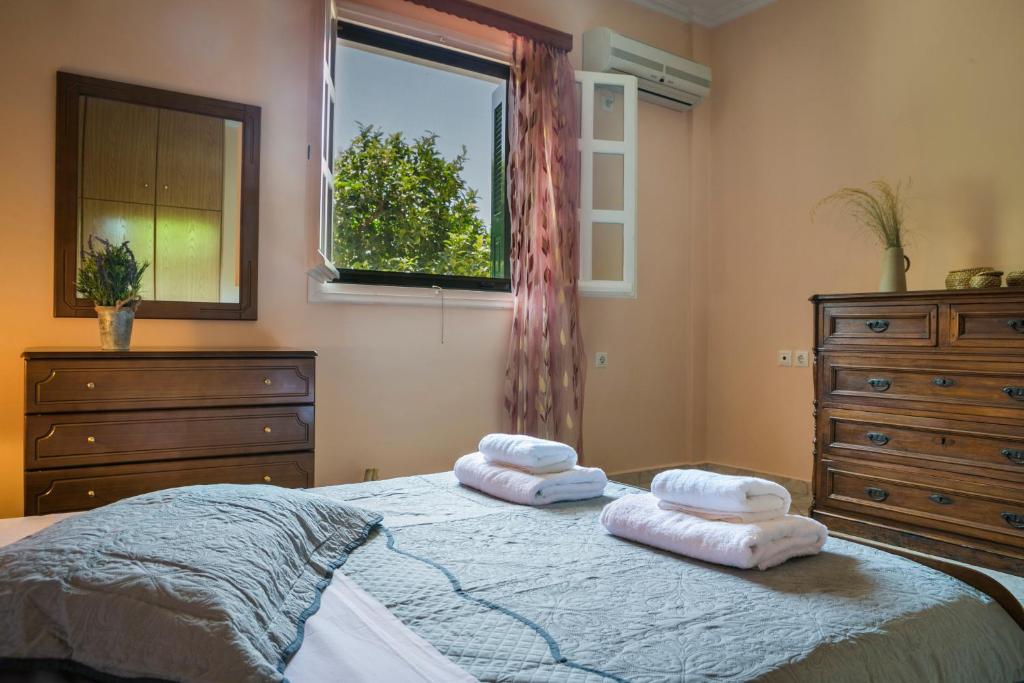 a bedroom with a bed with towels on it at Apartment Voula Myrtos in Anomeriá
